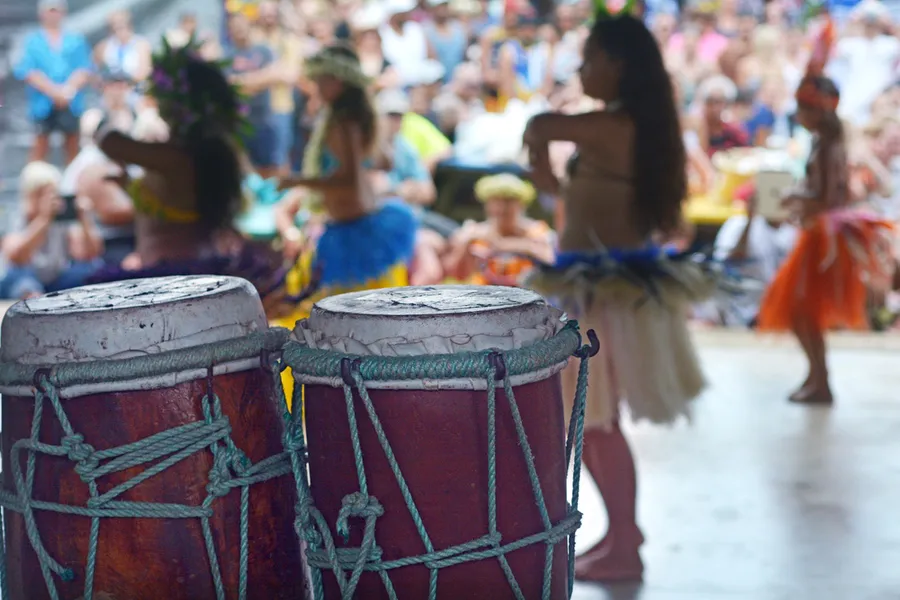 Traditional Polynesian drums at a Kauai luau with dancers in the background