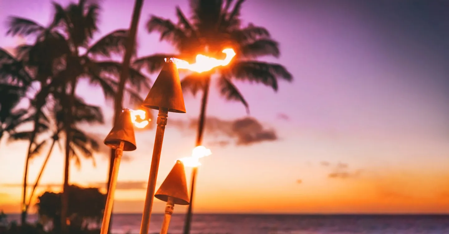 Tiki torches lit at sunset on the Big Island of Hawaii during a luau