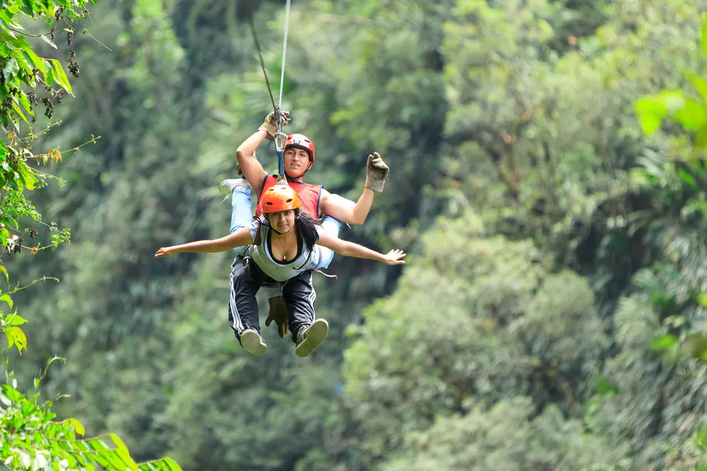 Person ziplining over the jungle canopy in Maui